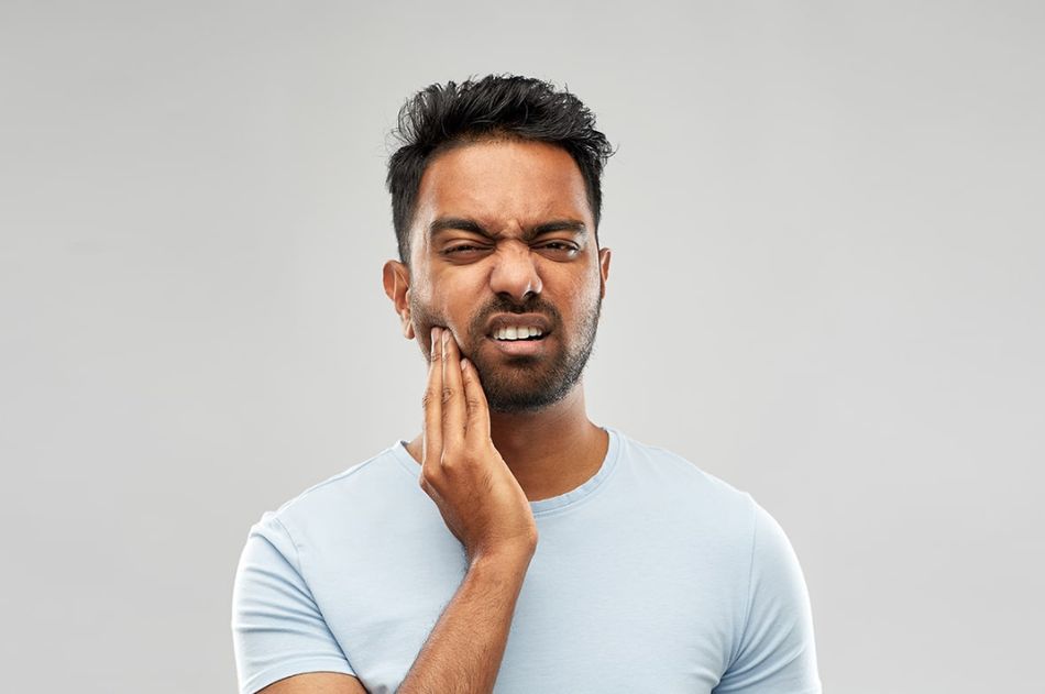 A man holding his jaw in pain